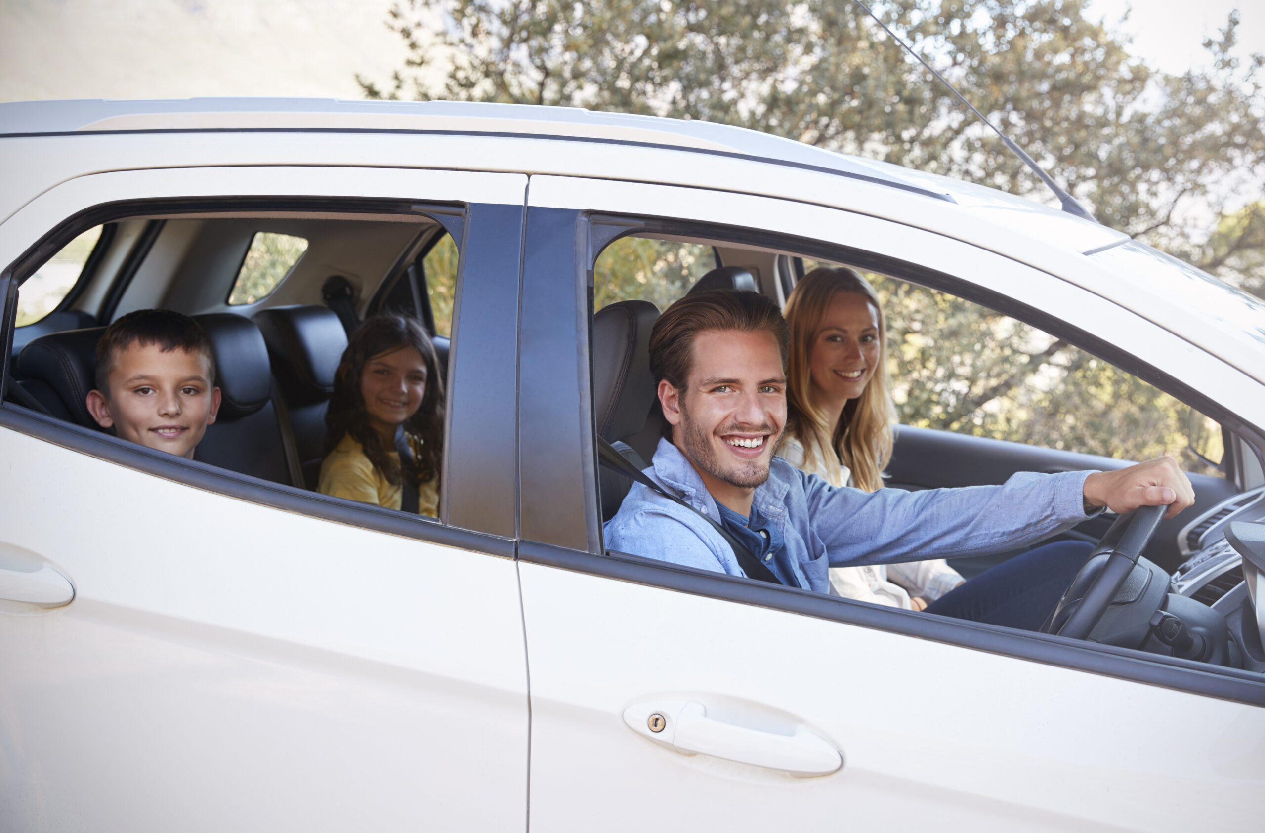 Famiglia sorridente in macchina verso i parchi divertimenti della Romagna